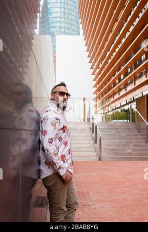 Vue latérale d'un homme barbu penchant sur un mur de bureau Banque D'Images