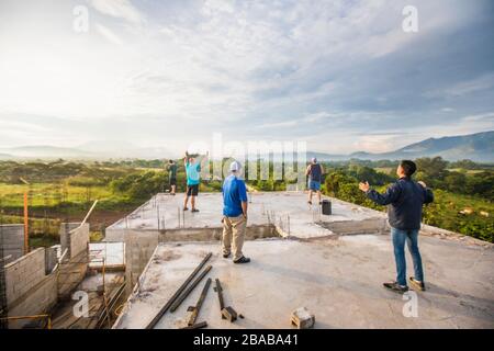 Groupe d'hommes qui louent Dieu depuis le toit le matin. Banque D'Images