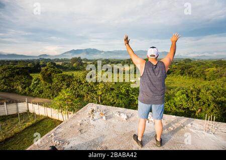 Homme louant et adorant Dieu tôt dans la matinée depuis le toit. Banque D'Images