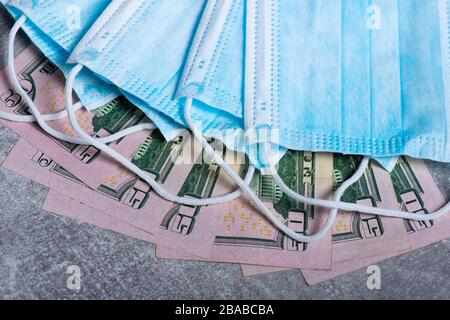 Masques de protection pour le visage avec factures en dollars. Spéculation et hausse des prix de la médecine. Des affaires pour la santé des gens. COVID 19 Coronavirus Banque D'Images