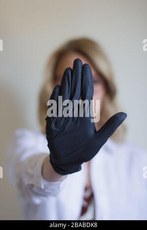 Femme montrant Stop Sign avec la main dans Glove Banque D'Images