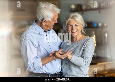 Heureux couple senior embrassant dans leur maison Banque D'Images
