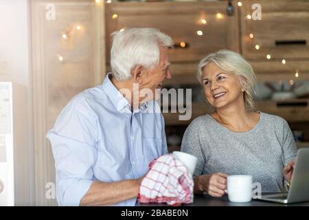 Heureux couple senior embrassant dans leur maison Banque D'Images