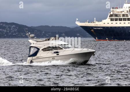 Petits bateaux de plaisance Peace, à Byfjorden en dehors du port de Bergen, Norvège. Passage du bateau de croisière Saga Sapphire Banque D'Images