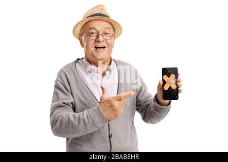 Homme âgé tenant un téléphone portable avec des emplâtres sur l'écran cassé isolé sur fond blanc Banque D'Images