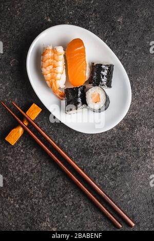 Cuisine japonaise à sushis. Les sushis Maki et nigiri roulent au saumon, au caviar, à l'avocat et au thon. Vue de dessus. Banque D'Images