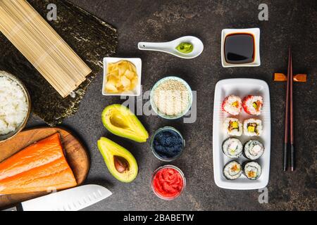 Cuisine japonaise à sushis. Les sushis Maki et california roulent au saumon, au caviar, à l'avocat, au thon et au wasabi au gingembre. Vue de dessus. Banque D'Images