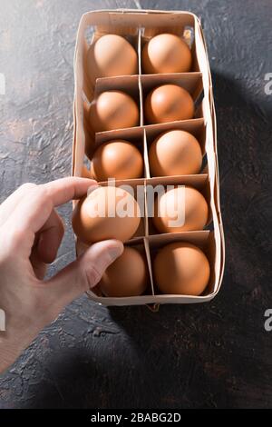 Oeufs de poulet crus dans les mains de la femme. Banque D'Images