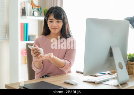 Femme asiatique utilisant la lotion ou hydrater comme main de leur vie quotidienne pour la protection de la peau pour devenir sèche et irritée après l'utilisation de gel antiseptique d'alcool Banque D'Images