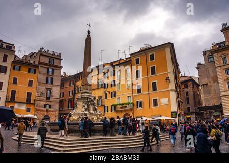 Foules de personnes devant Fontana del Pantheon sur la Piazza della Rotonda contre un ciel nuageux lors d'une journée de pluie à Rome, Italie Banque D'Images