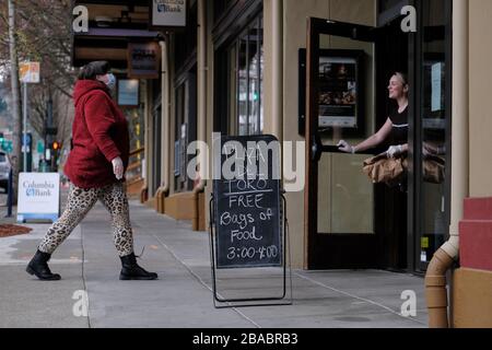 Portland, États-Unis. 26 mars 2020. Katie Grosz, directrice des affaires de la société gastronomique Plaza Del Toro et de l'espace événementiel privé, met à disposition des sacs de nourriture gratuits à Portland, Oregon, le 26 mars 2020. L'espace, appartenant au groupe de restaurants et de design Toro Bravo Inc., fournit également environ 50 déjeuners et 150 dîners par jour au Centre des congrès qui a été transformé en un abri temporaire pour les personnes à risque de contracter le nouveau coronavirus. (Photo d'Alex Milan Tracy/Sipa USA) crédit: SIPA USA/Alay Live News Banque D'Images