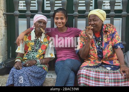 Des femmes fumeurs de cigares et un touriste, la Havane, Cuba Banque D'Images