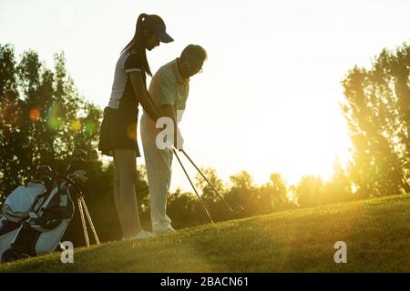 Jeunes femmes et personnes âgées pour jouer au golf Banque D'Images
