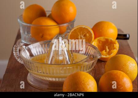 Fabrication de jus d'orange frais pressé, oranges sur la planche à découper avec alésoir à jus. Banque D'Images