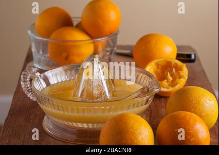 Fabrication de jus d'orange frais pressé, oranges sur la planche à découper avec alésoir à jus. Banque D'Images