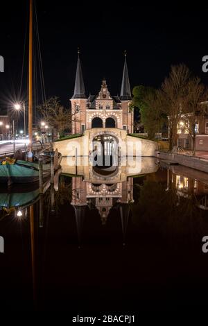 Long cliché de Waterpoort à Sneek pays-Bas, et son reflet sur le canal la nuit Banque D'Images