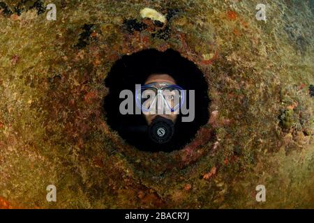 En regardant par un trou de port pendant la plongée sous-marine sur le site de plongée Gregory Banque D'Images