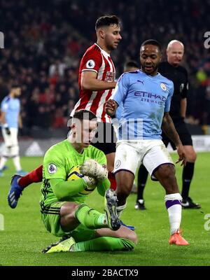 Le gardien de but de Sheffield, Dean Henderson, et le Raheem Sterling (à droite) de Manchester City, se battent pour le ballon Banque D'Images