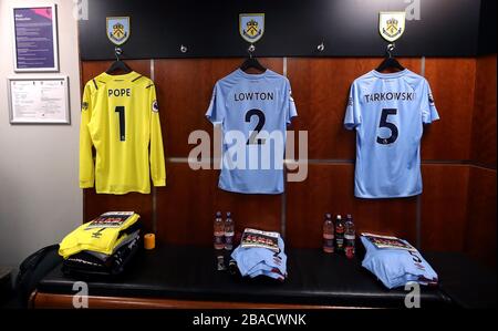 Les kits Burnley du gardien de but Nick Pope, Matthew Lowton et James Tarkowski pendent sur les crochets du dressing extérieur avant le match Banque D'Images