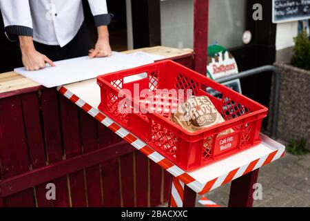 Weil am Rhein, Allemagne. 26 mars 2020. Un sac à pain se trouve dans une boîte sur une coulissement de marchandises que le maître boulanger Simon Fritz (l) a installé au drive improvisé de sa boulangerie. Le commerce de détail est déjà aux prises avec les conséquences de l'épidémie de corona et la baisse des ventes qui y est associée. Crédit: Philipp von Ditfurth/dpa/Alay Live News Banque D'Images