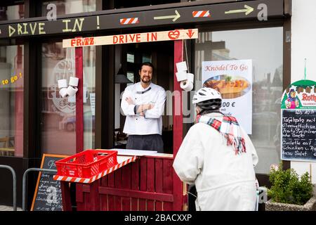 Weil am Rhein, Allemagne. 26 mars 2020. Le maître boulanger Simon Fritz se tient dans la fenêtre de la conduite improvisée de sa boulangerie et parle à un client qui est venu à vélo. Le commerce de détail est déjà aux prises avec les conséquences de l'épidémie de corona et la baisse des ventes qui y est associée. Crédit: Philipp von Ditfurth/dpa/Alay Live News Banque D'Images