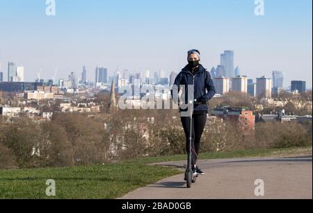 Londres, Royaume-Uni. 26 mars 2020. Une femme conduit son scooter jusqu'à Primrose Hill à Londres, Grande-Bretagne, le 26 mars 2020. Le gouvernement britannique a déclaré jeudi que le nombre de cas confirmés de COVID-19 dans le pays était passé à 11 658, les décès d'une journée ayant atteint 100 pour la première fois depuis l'apparition de la maladie. Crédit: Han Yan/Xinhua/Alay Live News Banque D'Images