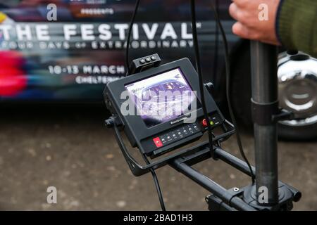 Le film Ed Chamberlin et Ollie Jackson d'ITV dans un taxi de marque Cheltenham Festival pendant la fête des essais du festival à l'hippodrome de Cheltenham. Banque D'Images