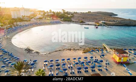 Vue panoramique sur la plage de Vathia Gonia, Ayia Napa, Famagusta, Chypre. L'attraction touristique historique baie rocheuse au lever du soleil avec sable doré, soleil Banque D'Images