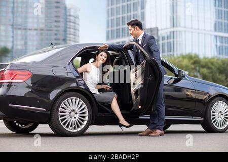 Une femme d'affaires chinoise confiante qui sort de sa voiture Banque D'Images
