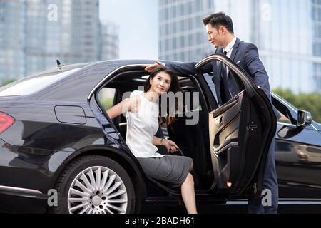 Une femme d'affaires chinoise confiante qui sort de sa voiture Banque D'Images