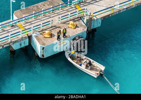 Ocho Rios, Jamaïque - 22 avril 2019: Amarrer gang et bateau à moteur avec corde de navire pendant l'opération d'amarrage au port de croisière dans les Caraïbes tropicales est Banque D'Images