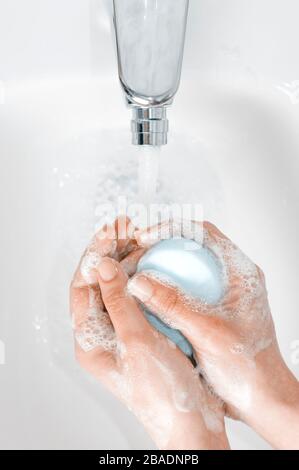 Concept de lavage des mains : une femme se moque des mains avant une routine complète de lavage des mains sous un robinet avec de l'eau courante Banque D'Images