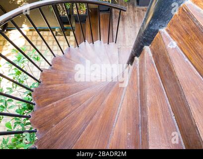 Escalier en colimaçon en bois avec rambarde en métal pour descendre jusqu'au sol. Banque D'Images