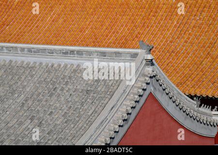 Gros plan sur un toit gris de l'un des anciens palais de la Cité interdite à Beijing en Chine, avec un toit orange brillant Banque D'Images