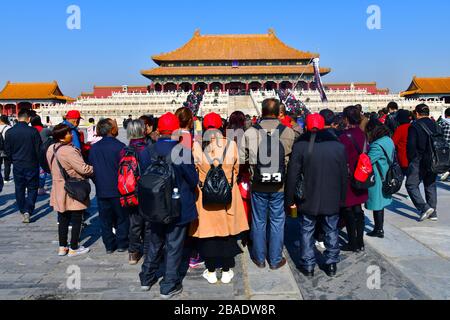 Pékin, Chine-octobre 2019 ; grand groupe de touristes vus de l'arrière à l'écoute d'un guide touristique avec dans l'arrière la salle de l'harmonie centrale Banque D'Images