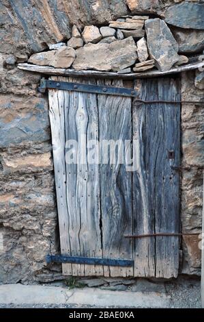 ancienne porte de la ferme en bois avec des pierres inhabituelles qui l'entourent Banque D'Images