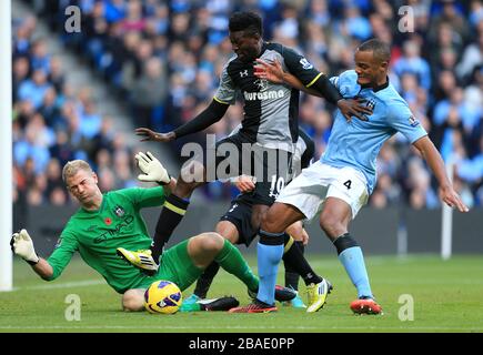 Emmanuel Adebayor (au centre) de Tottenham Hotspur lutte pour le ballon avec Vincent Kompany (à droite) et le gardien de but Joe Hart (à gauche) de Manchester City Banque D'Images