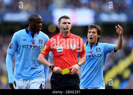 Yaya Toure de Manchester City et David Silva (à droite) font appel à l'arbitre Michael Oliver Banque D'Images