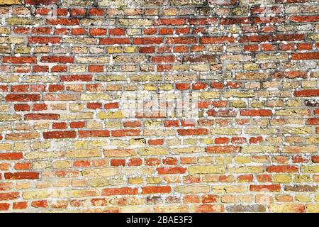 Le mur de jardin de château en briques colorées et dépeint en toile de fond est abstrait Banque D'Images