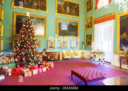 Un arbre de Noël joliment décoré entouré de cadeaux soigneusement enveloppés à l'intérieur de la maison Stourhead à Noël, Wiltshire, Angleterre, Royaume-Uni Banque D'Images