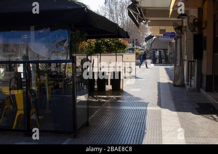 ALEXANDRAUPOLI, GRÈCE - 21 mars 2020 - un homme passe devant l'un des nombreux cafés fermés du centre-ville d'Alexandraupoli, Grèce. La plupart des entreprises, cafés, bars Banque D'Images