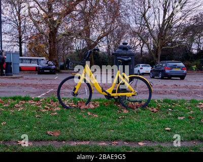 Londres, Royaume-Uni - 10 décembre 2018 : location de vélos Ofo jaune à Battersea Park Londres avec des voitures garées en arrière-plan. OFO ne fonctionne plus en Lo Banque D'Images