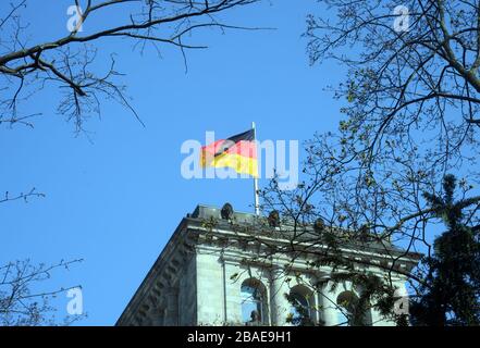 Berlin, Allemagne. 27 mars 2020. Le drapeau de l'Allemagne se réveillonne au vent depuis le sommet du bâtiment du Bundestag, le parlement fédéral allemand de Berlin. Crédit: Gonzales photo/Alay Live News Banque D'Images