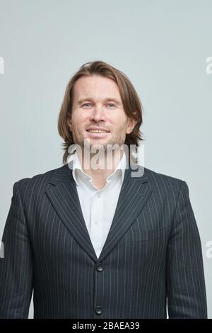 Le beau homme en costume noir, homme brutal avec de longs cheveux, homme d'affaires, très élégant, portrait, émotions sur le visage, victoire, confiance, plaisir Banque D'Images