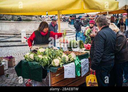 Brno, Moravia, République tchèque - 28 octobre 2018: Femme vendant des légumes et des fruits sur un marché agricole sur Zelny TRH à Brno, République tchèque avec Peop Banque D'Images