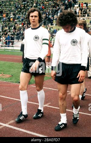 Le capitaine de l'Allemagne de l'Ouest Franz Beckenbauer (à gauche) se promène avec son coéquipier Paul Breitner (à droite) Banque D'Images