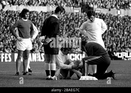 Le mari Jimmy d'Everton (l) et Johnny Giles (r) de Leeds United's ont l'air comme l'entraîneur United de Leeds les Cocker traite un chasseur normand blessé (c) Banque D'Images