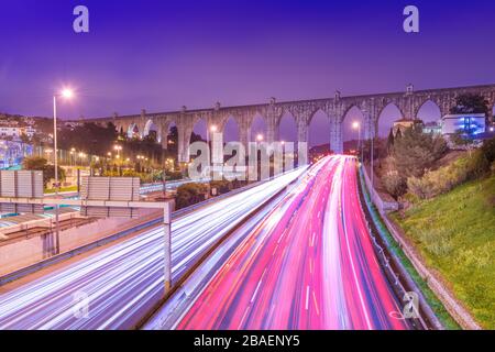 Vue sur l'autoroute avec circulation automobile et sentiers légers. L'Aguas Livres Aqueduct (Aqueduto das Águas Livres) à Lisbonne, Portugal Banque D'Images