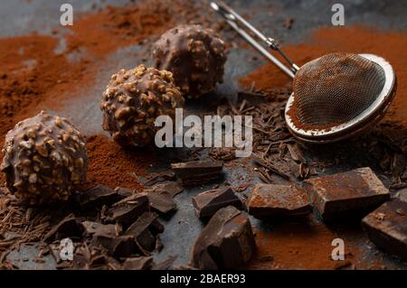 Truffes maison au chocolat noir et aux noix entourées de morceaux de chocolat et de poudre de cacao Banque D'Images