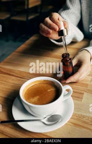 Ajouter de l'huile CBD dans une tasse à café Banque D'Images